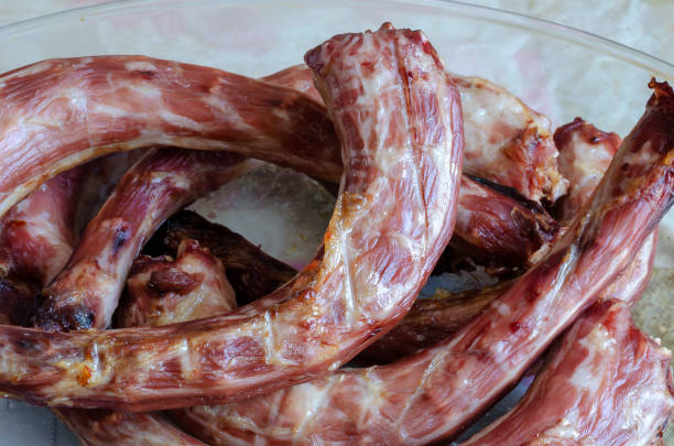 Sun-dried turkey necks in a glass dish. Close-up of fragrant delicacies. Cooking process. Selective focus