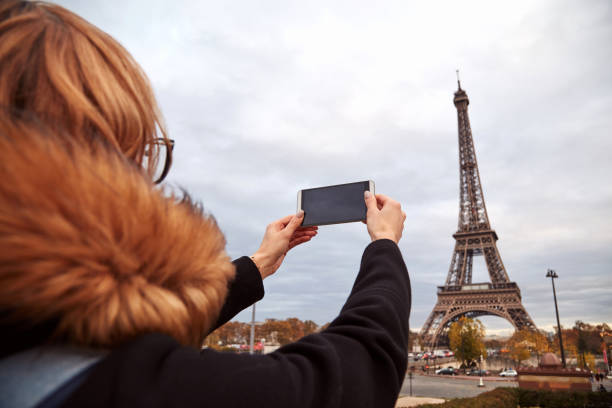istock Girl using cellphone with Paris city background and Eiffel tower. 1254965577