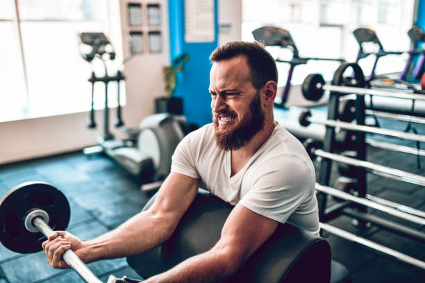 atleta masculino fazendo treino de braço com barbell na academia - gym weight bench exercising weights - fotografias e filmes do acervo