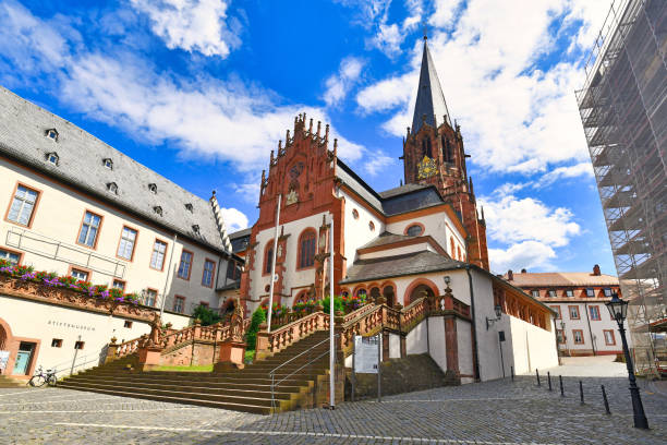 Aschaffenburg, Germany - July 2020: Catholic curch called 'Kollegiatsstift St. Peter und Alexander' or 'Stiftskirche' or 'Basilica of St. Peter and Alexande' in historic city center on sunny day. The associated collegiate church was classified historical monument of Bavaria. Situated on top of a hill, the church has good views of the city of Aschaffenburg. The architecture of the monastery reflects different periods, from pre-Romanesque to the seventeenth century, although most of the current buildings date back to the 12th and 13th centuries.