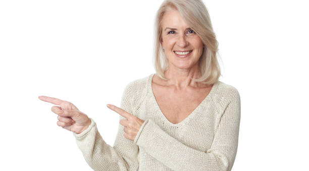 istock Senior lady is pointing fingers to copy space. Isolated 1254971566
