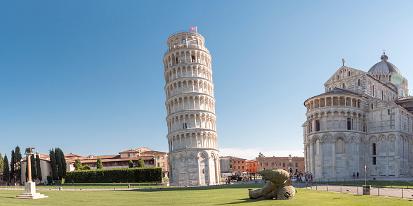 Cathedral and Leaning Tower of Pisa on a bright summer day with beautiful green grass and blue sky. Tuscany, Italy