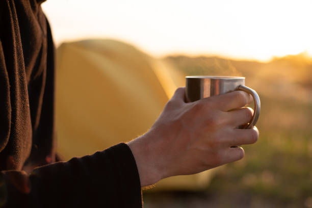 istock A man with a metal mug in his hands at sunset 1254974976
