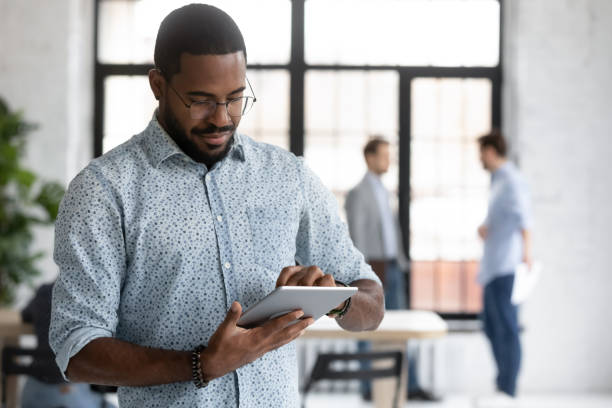 istock Concentrated African businessman preparing presentation on electronic tablet 1254975557