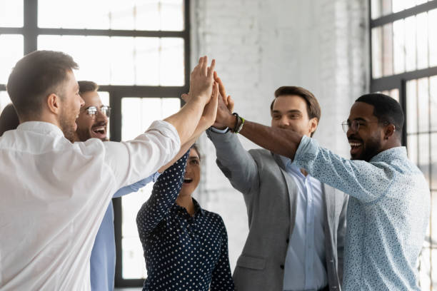 istock Multiracial affiliates join hands giving high five celebrating common success 1254975563