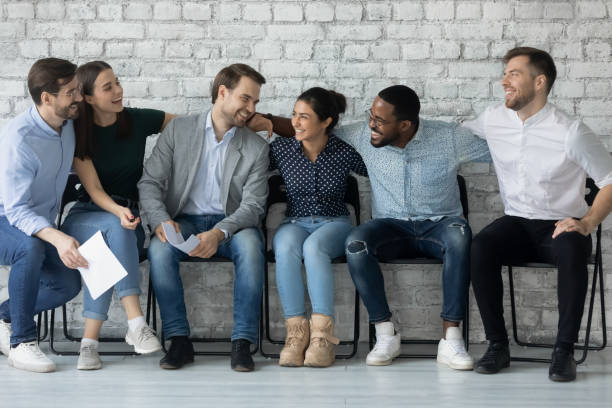 istock Multiethnic employees sit on chairs in office corridor enjoy communication 1254975593