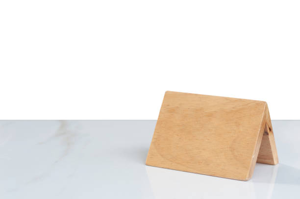 istock Wood reservation sign on marble table with white background, blank sign for texting. 1254975619