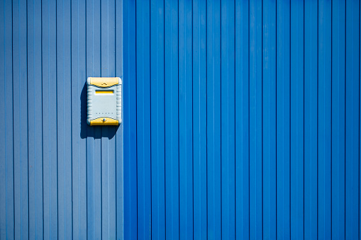 Light mailbox on a blue fence
