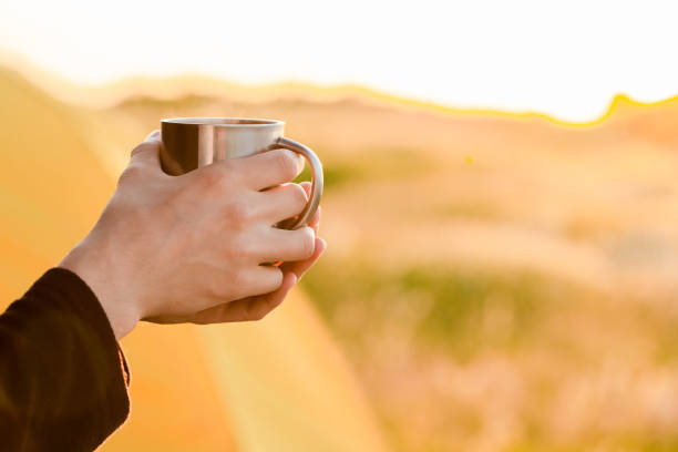 istock A man with a metal mug in his hands at sunset 1254978206