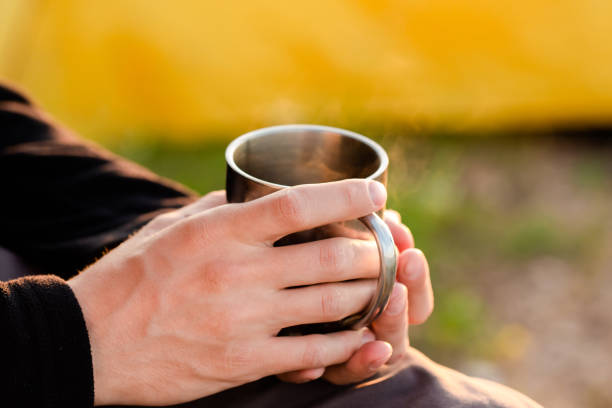 istock A man with a metal mug in his hands at sunset 1254978219