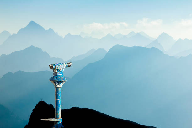 public binoculars and mountain silhouettes at sunrise. foresight and vision for new business concepts and creative ideas. alps, allgau, bavaria, germany. - conceptual vision imagens e fotografias de stock