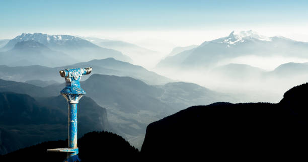 binocolo pubblico e sagome di montagna all'alba. lungimiranza e visione per nuovi concetti di business e idee creative. alpi, trentino, alto adige, italia. - horizon observatory foto e immagini stock