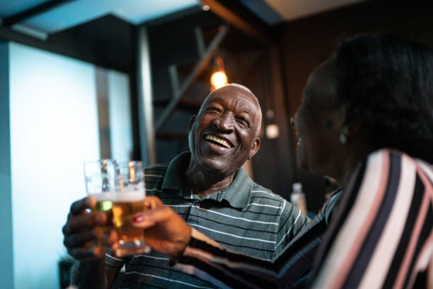 Senior couple toasting beer in a bar Senior couple toasting beer in a bar people bar bar counter restaurant stock pictures, royalty-free photos & images