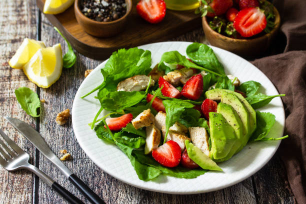 istock Lunch for keto. Summer salad with strawberries, grilled chicken and avocado on a rustic table. 1254985473