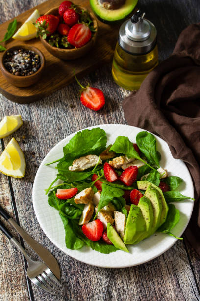istock Lunch for keto. Summer salad with strawberries, grilled chicken and avocado on a rustic table. 1254985478