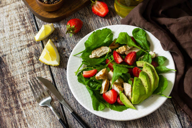 istock Lunch for keto. Summer salad with strawberries, grilled chicken and avocado on a rustic table. Copy space. 1254985482