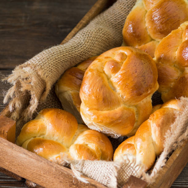 istock Rolls in a wooden box on a brown wooden table. Rustic pastries. Rustic style 1254986297
