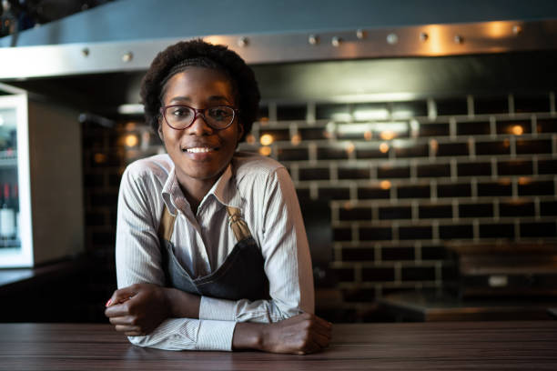 ritratto di cameriera felice dietro il bancone - owner small business restaurant african ethnicity foto e immagini stock