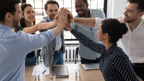 istock Excited multiethnic staff members giving high five sharing success 1254988641