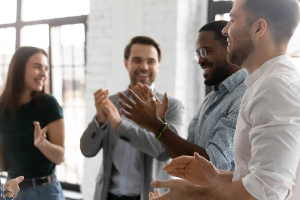 istock Enthusiastic businesspeople clap hands congratulating each other with common success 1254988910