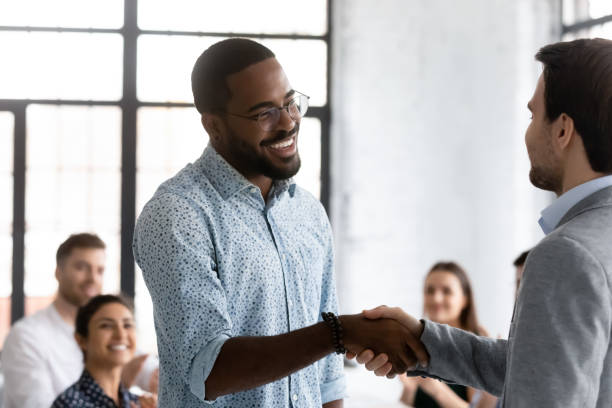 istock African employee got promotion feels happy shake hands with boss 1254989168
