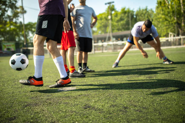 Male friends doing warm-up routine at soccer field