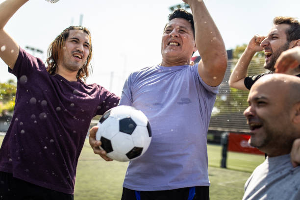 istock Teammates celebrating winning a match at soccer field 1254992435