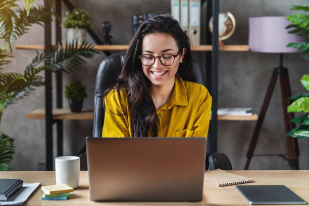 jovem mulher de negócios feliz bonito sentar-se dentro de home office usando computador laptop - home buisness - fotografias e filmes do acervo