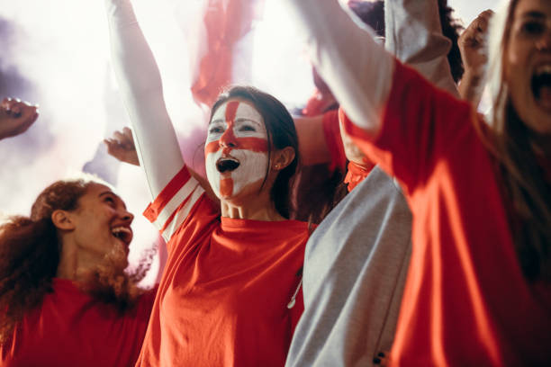 istock Devoted soccer fans in stadium cheering a goal 1254993939