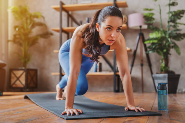 young woman doing sport exercises indoor at home - stretching women attractive female indoors imagens e fotografias de stock