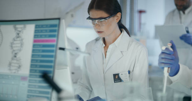 istock Female scientist studying DNA mutations. Research partner in background 1254996498