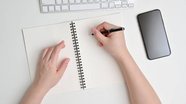 istock Top view of woman hand's writing on notebook 1254997667