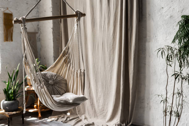 istock Textile hanging swing with cushions in white room 1254998635
