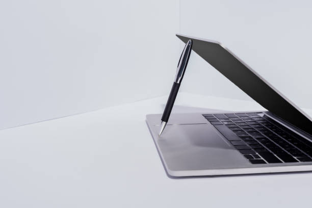 istock pen in modern laptop on white background 1255003419