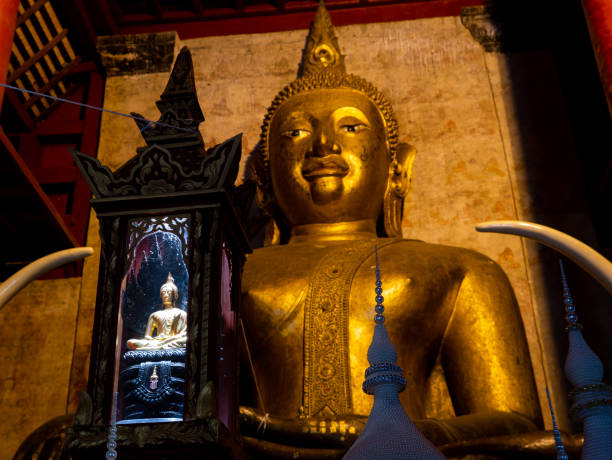 istock Small Buddha Statue Siting in front of The Large Buddha Sitting in The Back 1255005212