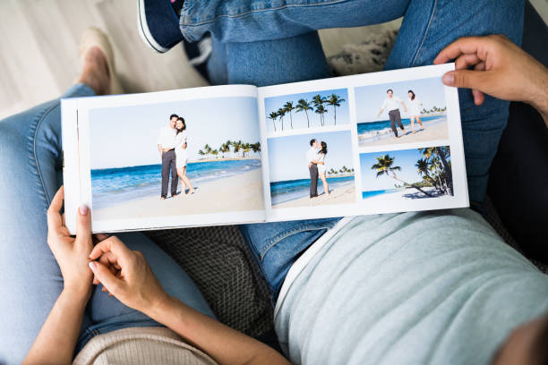 Couple Family Looking Photo Album Couple Family Looking Photo Album Or Photobook honeymoon book stock pictures, royalty-free photos & images