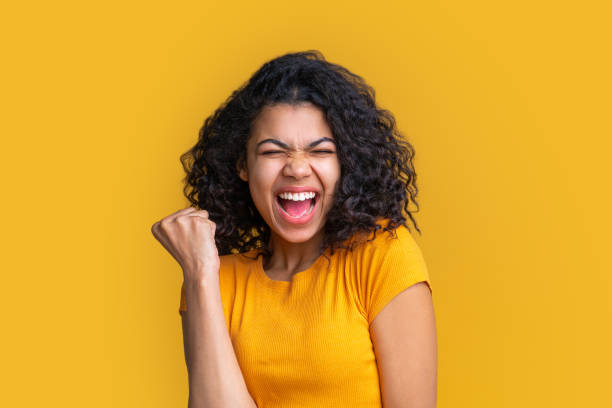 studio shot of cute african american girl on bright yellow background - smiling casino human hand beautiful imagens e fotografias de stock