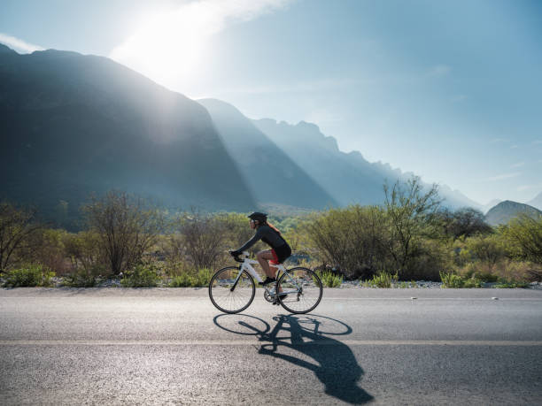 Latin cyclist on the road with bike - fotografia de stock