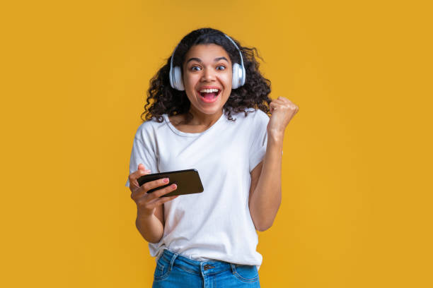 studio shot of cute african american girl on bright yellow background - smiling casino human hand beautiful imagens e fotografias de stock