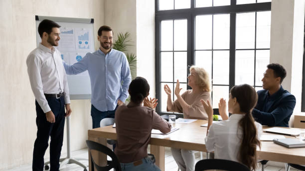 istock Smiling executive introducing new hired employee at corporate meeting 1255011670