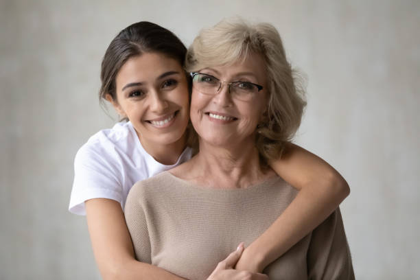 retrato de la cabeza cariñosa hija abrazando madre madura de la espalda - senior women grandmother glasses senior adult fotografías e imágenes de stock