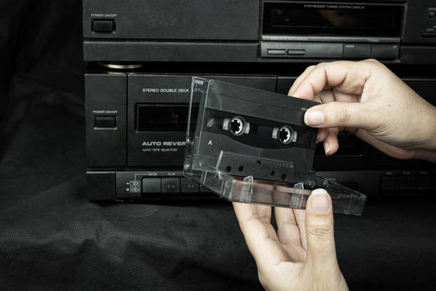 l'inserimento a mano da donna di cassette compatte nell'audio del vecchio lettore è una tecnologia retrò - human finger audio foto e immagini stock