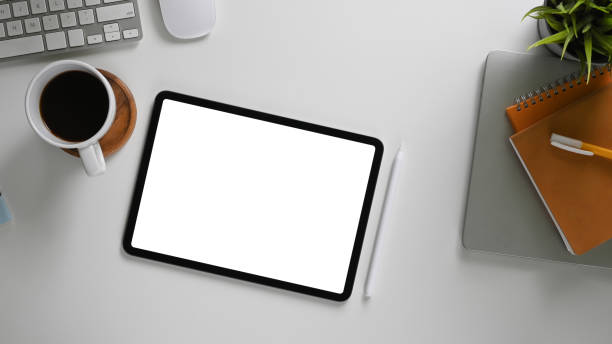 istock The top view image of a white blank screen computer tablet is putting on a comfortable working desk. 1255011930