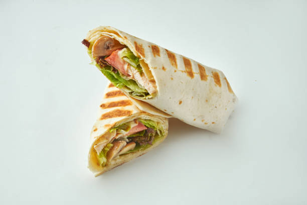 Fresh roll with chicken, tomatoes, cheese and lettuce in pita bread on a white background. Baked Chicken Shawarma