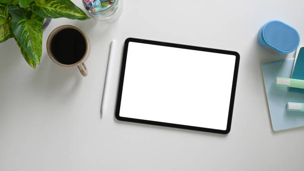istock The top view image of a white blank screen computer tablet is putting on a comfortable working desk. 1255012586