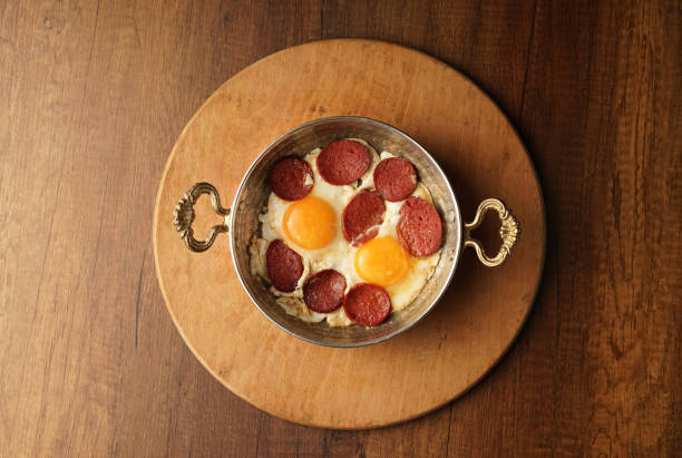 istock Turkish Sausage (sucuk) and egg isolated on rustic wooden table 1255013478