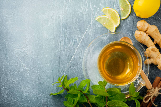 istock Useful ginger tea with mint, lemon and sugar in a transparent cup on a concrete blue background. Selective focus. Top view. 1255014600