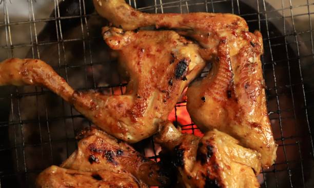 istock Making Grilled Chicken on Charcoal Flame in Earthenware Stove 1255014626