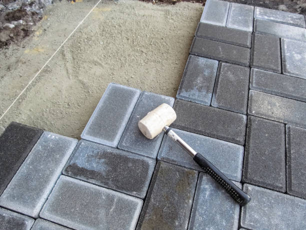 A white rubber mallet lies on the surface of a gray Brick paving slab A white rubber mallet lies on the surface of a gray Brick paving slab. Tools and materials for paving works. Beautiful building background with copy space rubber rocks stock pictures, royalty-free photos & images