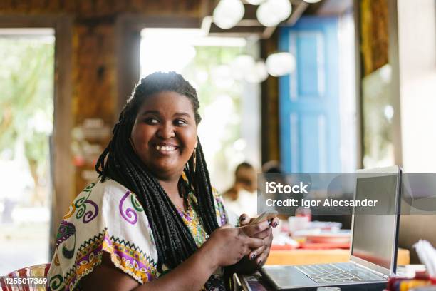 Afro Woman Holding Smartphone In Office Stock Photo - Download Image Now - Laptop, African-American Ethnicity, One Woman Only